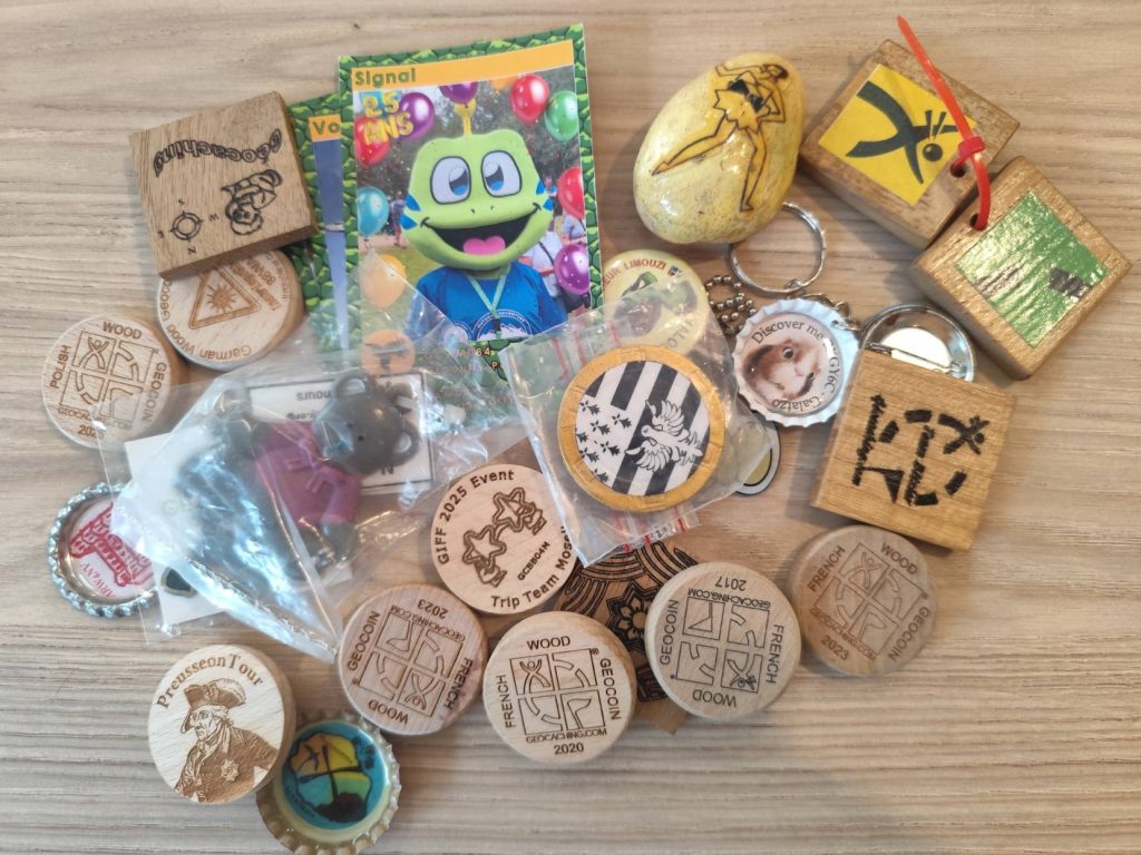 Collection d’objets signature de géocacheurs réunis sur une table